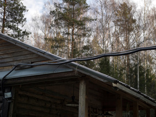 Fototapeta na wymiar Electric power line and wooden house