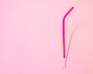 Pink metal straw and wash brush on a pink background