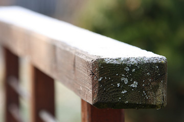 Wooden railing with gray lichen at the end