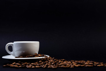 Tazza di caffè su sfondo nero e chicchi tostati