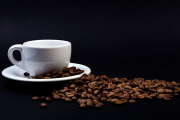 Tazza di caffè su sfondo nero e chicchi tostati