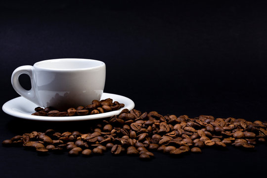 Tazza di caffè su sfondo nero e chicchi tostati © fotonat67