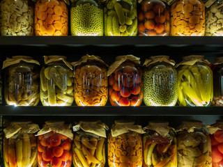 The stacks of big transparent glass jars with pickled vegetables