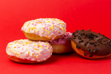 Ciambelle glassate su sfondo rosso