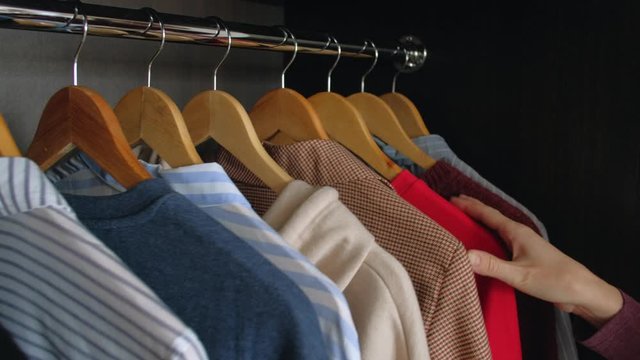 Woman hands takes business shirt from your wardrobe in home. Close-up. Shopping concept.