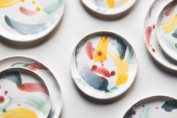 Hand-painted ceramic plates. Collection of colorful ceramic on white background