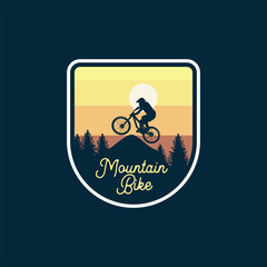 mountain bike badge jump silhouette yellow sky background. logo sign patch design