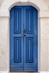 Fototapeta na wymiar Blue paneled door in a stone arch.