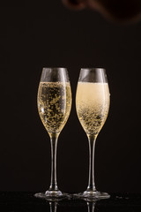 pour champagne in two glasses on a white or black background