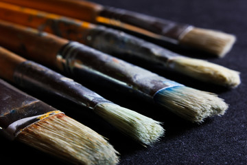 Fototapeta premium Used Oil paint brushes on a Black background