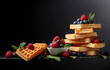 Belgian waffles with  blueberries, raspberries  and fresh mint.