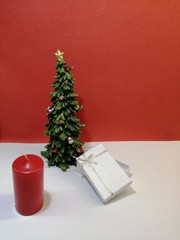 little christmas tree with white gift box and romantic red candles