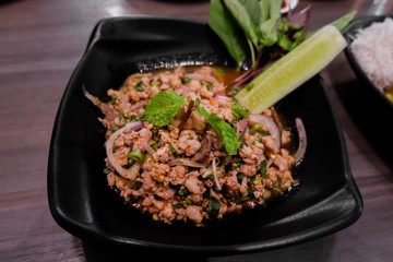 Spicy minced pork in black plate.