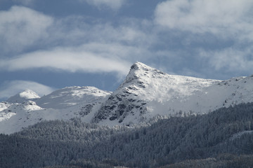 Fototapeta premium Blick von Innsbruck im Inntal in Tirol auf die Neunerspitze und Viggarspitze und die schneebedeckten Gipfel im Winter