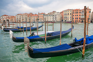 Fototapeta na wymiar Gondolas moored to the wooden harbour in Venice