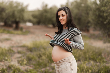 Pregnant woman in nature showing her belly