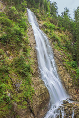 Obraz premium Standing at the base of the waterfall at the entrance of the Kitzlochklamm, a deep gorge near Zell am See