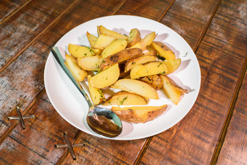 Delicious freshly cooked rustic potatoes on a large wooden table