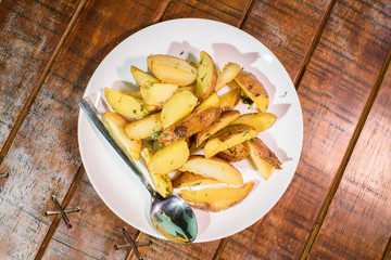 Delicious freshly cooked rustic potatoes on a large wooden table