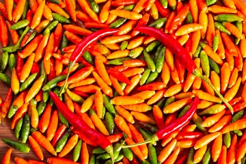 colorful chilli peppers on wooden table