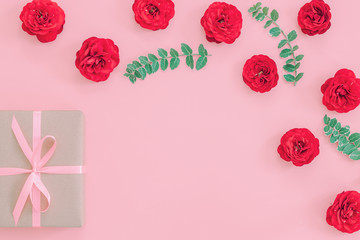 Gift or present box wrapped in kraft paper and rose flower on pi
