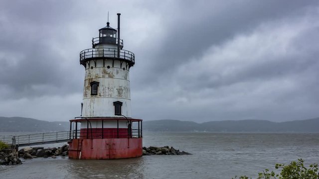 Time lapse of the lighthouse of Sleepy Hollow / Tarry Town. NY at the Hudson river on a rainy day. Gray clouds moving and boats passing by.