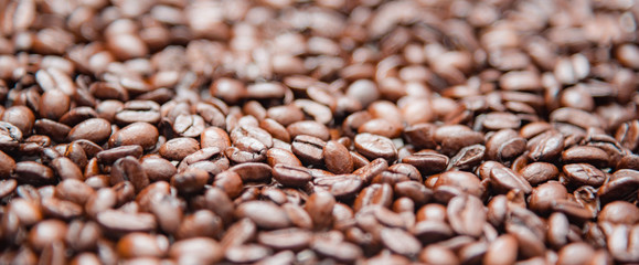 Close up whole roasted coffee beans background texture.