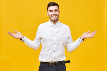 I have no idea. Studio shot of emotional attractive young unshaven man smiling happily, spreading...