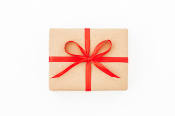 Isolated present or gift box in craft paper with red ribbon bow