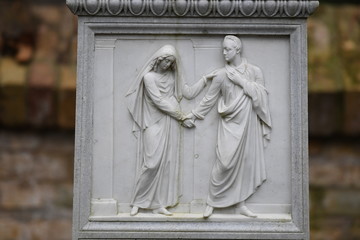Fototapeta premium An old sandstone relief that shows a man who forgives a young woman.