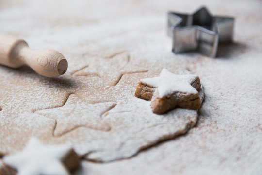 Ginger dough and other Christmas baking ingredients on the table. Star shape cookies preparation.