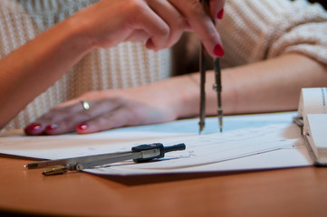 a woman draws a drawing with a compass