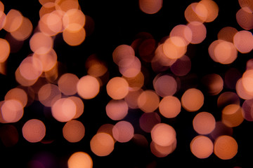 Unfocused pink bokeh lights on dark background.