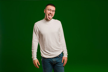 young handsome man with cheerful, carefree, rebellious attitude, joking and sticking tongue out,...