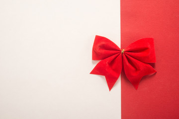 Red gift bow on white and red background