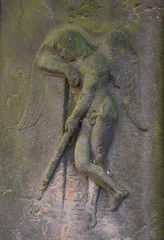 A sandstone relief of an angel with a sword in her hand who leans against a wall.