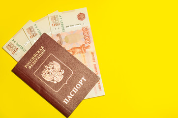 Russian national and international passports and russian moneys, document and travel concept, flat lay at the yellow background with copyspace for a text