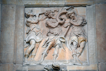 An old, weathered sandstone relief of trumpet playing angels in Potsdam-Germany. 