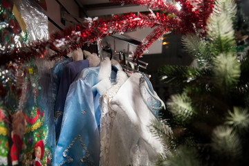 Fototapeta na wymiar Clothes for Russian Christmas characters: Santa Claus Santa Claus and snow maiden snow maiden . Clothes hang in a row on hangers, sold in the store. Christmas clothes.