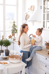 Mother and daughter spending time together at Christmas kitchen. Cozy home concept.