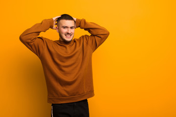 young handsome man feeling stressed, worried, anxious or scared, with hands on head, panicking at...