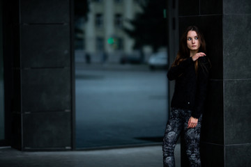 Teenager. Young pretty white caucasian teenage girl with long hair with problem skin and long hair in casual clothes near a modern building in cold weather in autumn.