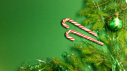  Christmas card with spruce and holiday decorations, sweets, on a green background. Christmas template for banner, ticket, brochure, card, invitation, poster, etc.