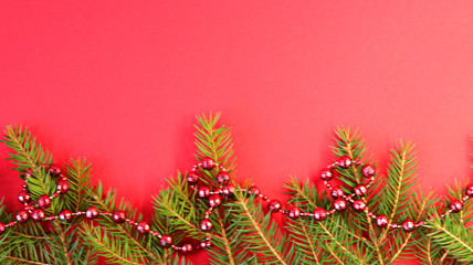 Christmas composition Christmas decorations, fir branches with a red background. Flat design, side view, copy space.