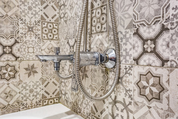 water tap sink with faucet in expensive loft bathroom. detail of a corner shower cabin with wall mount shower attachment