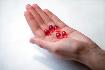 red medicine capsules lie on the hand, take medicines