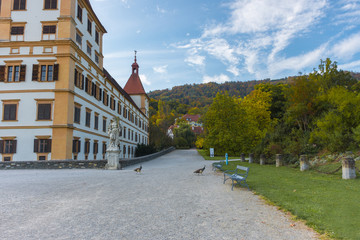 Colorful autumn colors, bright blue sky in the park and Eggenberg Palace in Graz, Styria region, Austria