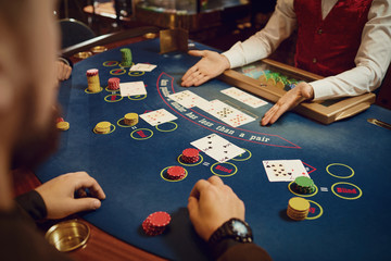 Hands of players and croupiers in the game cards. - obrazy, fototapety, plakaty