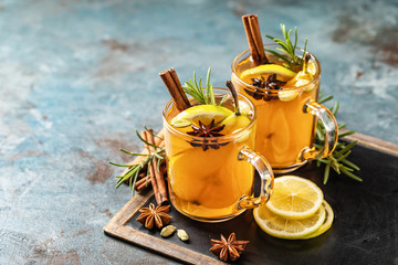 Hot drink cocktail for New Year, Christmas, winter or autumn holidays..Toddy. Mulled pear cider or spiced tea or grog with lemon, pear, cinnamon, anise, cardamom, rosemary. - 305071674