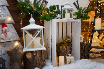 Merry Christmas and Happy New Year decorations, wooden box, lantern, fir tree branches and festive garland lights. Winter holidays concept.